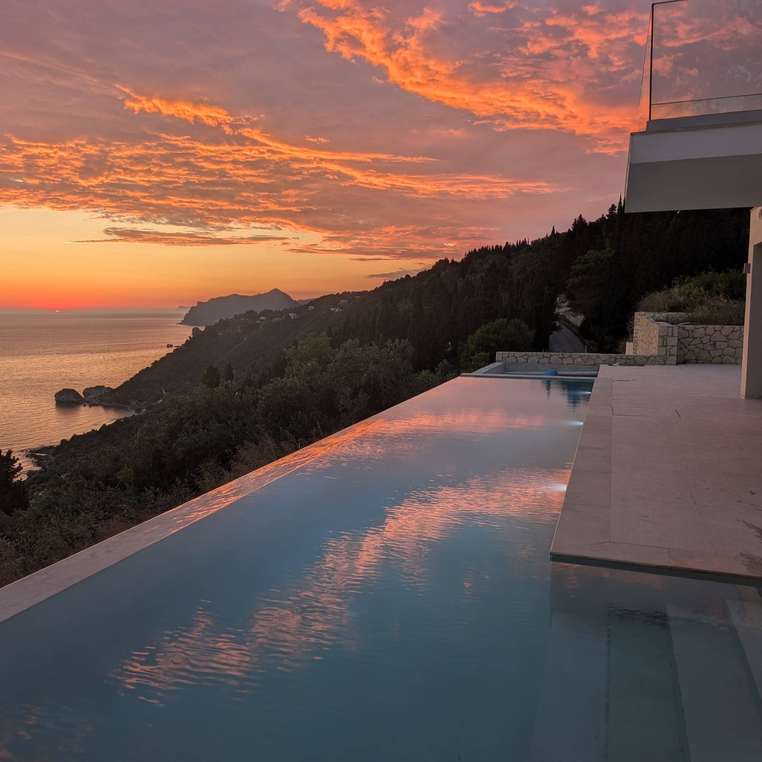 Sunset reflected across the Villa Norma infinity pool and Corfu coastline